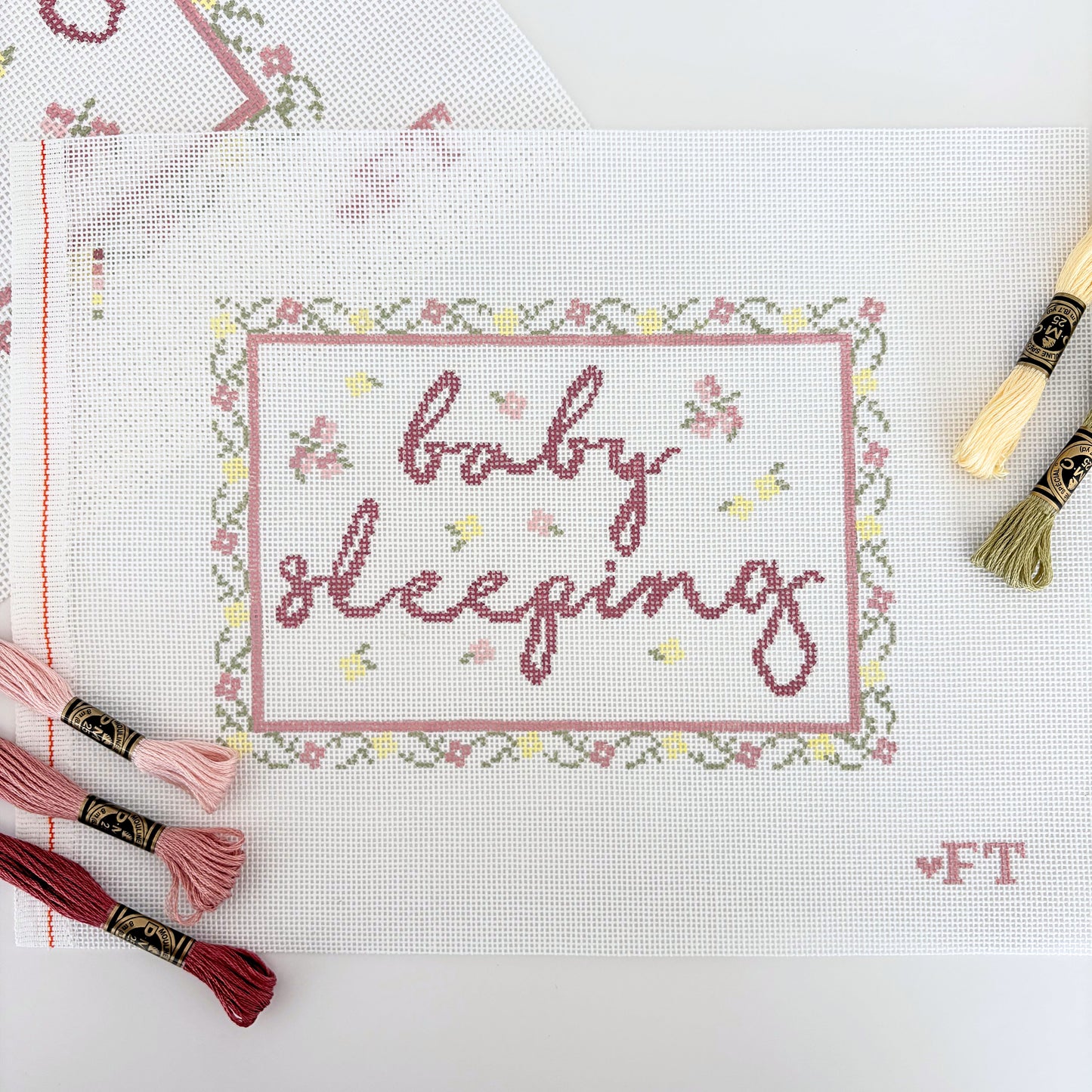 Floral needlepoint frame with "baby sleeping" text 