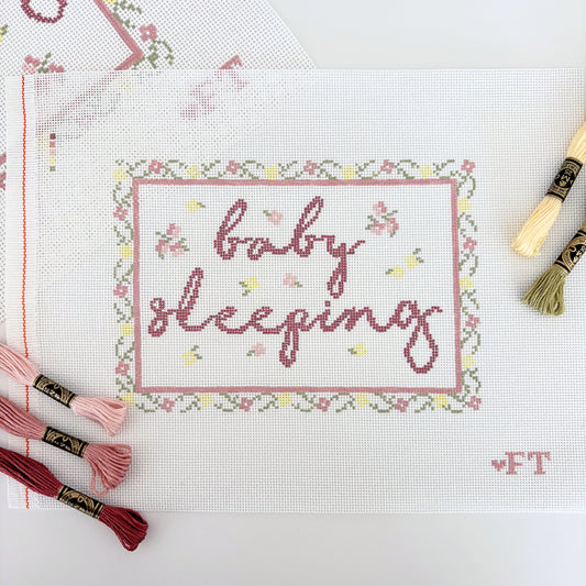 Floral needlepoint frame with "baby sleeping" text 